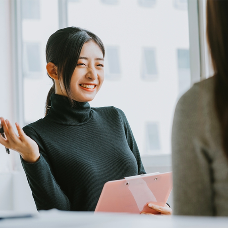 女性のコンシェルジュが笑顔で説明している様子